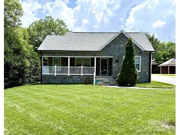 Charming stone-clad home featuring a welcoming front porch and a well-manicured lawn at 1004 Venus St, Kannapolis, NC 28083