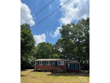 Charming blue and brick home with manicured landscaping and a lush green lawn at 1320 Kings Cir, Shelby, NC 28150