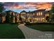 Elegant residence with exterior lighting illuminating the meticulously landscaped grounds and stone walkway at 18019 Harbor Light Blvd, Cornelius, NC 28031