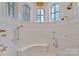 Luxurious bathroom with multiple shower heads, arched windows, and custom tile work at 18019 Harbor Light Blvd, Cornelius, NC 28031