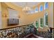 Elegant staircase with iron railing leading to a landing with arched windows and a chandelier at 18019 Harbor Light Blvd, Cornelius, NC 28031