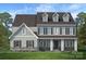 Inviting new home features a stone-accented facade, a covered porch, and lush landscaping at 11318 James Coy Rd # Devonshire, Davidson, NC 28036