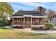 Brick house with front porch, rocking chairs, and landscaped lawn at 3726 The Plaza None, Charlotte, NC 28205