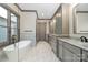 Sleek bathroom showcasing gray cabinetry, a freestanding tub, and marble countertops at 8159 Fairview Rd, Charlotte, NC 28226
