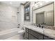 Stylish bathroom with granite counters, a tub with tile surround, and gray cabinets at 8159 Fairview Rd, Charlotte, NC 28226