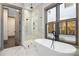 Modern bathroom featuring a freestanding tub, glass shower, and marble tile at 8159 Fairview Rd, Charlotte, NC 28226