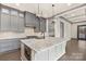 Bright kitchen features gray cabinets, a large island with marble countertops, and pendant lighting at 8159 Fairview Rd, Charlotte, NC 28226