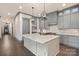 Modern kitchen with gray cabinets, marble island, stainless steel appliances, and hardwood flooring at 8159 Fairview Rd, Charlotte, NC 28226