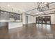 Spacious living room featuring gray cabinets, a kitchen, and coffered ceilings with lighting at 8159 Fairview Rd, Charlotte, NC 28226