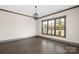 Minimalist living room features a large window for natural light and hardwood floors at 8159 Fairview Rd, Charlotte, NC 28226