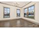Bright living room with large windows, chandelier, and hardwood flooring at 8159 Fairview Rd, Charlotte, NC 28226