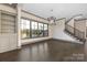 Bright living room featuring dark trim windows, a staircase, and hardwood flooring at 8159 Fairview Rd, Charlotte, NC 28226