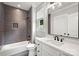 Bathroom featuring a vanity with quartz countertop, black hardware, and a shower over tub with gray subway tile at 8163 Fairview Rd, Charlotte, NC 28226