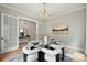 Stylish dining room featuring a glass-top table, plush white chairs, and elegant lighting, perfect for entertaining at 8163 Fairview Rd, Charlotte, NC 28226
