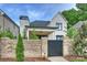 Elegant white brick home behind a brick wall, featuring a covered porch and lush greenery, showcasing curb appeal at 8163 Fairview Rd, Charlotte, NC 28226