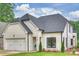 Beautiful white brick home with a three-car garage and a manicured lawn under a partly cloudy sky at 8163 Fairview Rd, Charlotte, NC 28226