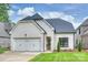 Attractive white brick home featuring a three-car garage, accented by a well-kept lawn under a partly cloudy sky at 8163 Fairview Rd, Charlotte, NC 28226