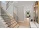 Bright foyer featuring a staircase with black iron railings and light wood floors, creating an inviting entrance at 8163 Fairview Rd, Charlotte, NC 28226