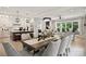 Open concept kitchen with modern appliances, island seating, and connected dining and living areas at 8163 Fairview Rd, Charlotte, NC 28226