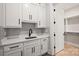 Functional laundry area featuring stylish white cabinetry, modern fixtures, quartz countertop, and convenient access to a closet at 8163 Fairview Rd, Charlotte, NC 28226