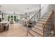 Bright, open concept living space with staircase, dining area, and living room with large windows at 8163 Fairview Rd, Charlotte, NC 28226