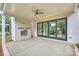 Covered patio with brick fireplace, ceiling fan and sliding doors overlooking the backyard, perfect for entertaining at 8163 Fairview Rd, Charlotte, NC 28226