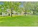 Expansive, well-maintained backyard featuring lush lawn, chain-link fence, and mature trees providing ample shade at 506 E Maine Ave, Bessemer City, NC 28016