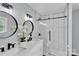 Modern bathroom featuring double sinks, sleek fixtures, and a tiled shower with glass doors at 506 E Maine Ave, Bessemer City, NC 28016
