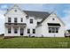 Bright and modern two-story home with a covered porch, black metal accents, and a well-maintained lawn at 841 Lake Forest Dr # Hawthorne, Belmont, NC 28012