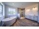 Bright bathroom featuring a soaking tub, glass shower, double vanity, and wood flooring at 843 Lake Forest Dr # Devonshire, Belmont, NC 28012