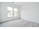 Bright bedroom with gray carpet and a large window at 5217 Glenwalk Dr # 0059, Charlotte, NC 28269