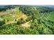 Aerial view showcasing the property's boundaries, home, outbuilding, and surrounding mature trees at 6051 Pointe West Ln, Vale, NC 28168