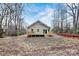 Backyard view of a cozy home with a wooden deck, surrounded by trees and a natural landscape at 6051 Pointe West Ln, Vale, NC 28168