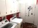 A laundry room with overhead storage and modern washer and dryer at 2535 Fairfax Dr, Gastonia, NC 28054