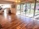 Bright living room boasting wood floors, glass sliding doors to the patio, stairs to the basement, and a chandelier at 2535 Fairfax Dr, Gastonia, NC 28054