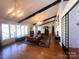 Open-concept living room featuring high ceilings, exposed beams, large windows, and a comfortable seating area at 2535 Fairfax Dr, Gastonia, NC 28054