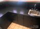 An interior wet bar features black cabinetry, countertop, stainless steel sink, and tile flooring at 2535 Fairfax Dr, Gastonia, NC 28054
