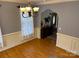 Bright dining room featuring hardwood floors, wainscoting, neutral colors, and elegant chandelier at 1491 Hwy 160 E Rd, Fort Mill, SC 29715