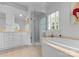 Bright bathroom features a standalone shower, tub, and a large vanity with storage at 4016 Nettie Ct, Charlotte, NC 28211