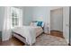 Bright bedroom features hardwood floors, an area rug, large window, and neutral paint at 4016 Nettie Ct, Charlotte, NC 28211