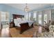 Luxurious main bedroom suite with a large bed, chandelier, hardwood floors, and abundant natural light at 4016 Nettie Ct, Charlotte, NC 28211