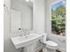 Bright powder room with a pedestal sink, modern fixtures, and a window at 1428 Hamilton St # 13, Charlotte, NC 28206