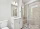 Bright bathroom with a glass shower enclosure featuring bench seating and modern fixtures at 1428 Hamilton St # 13, Charlotte, NC 28206