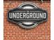 Sign showing the name of The Underground event space, mounted on a brick wall at 1428 Hamilton St # 13, Charlotte, NC 28206