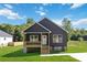 Inviting home with a covered porch, dark siding, white trim, and a spacious green lawn at 213 Sheffield Dr, York, SC 29745