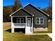 Charming home with dark siding, white trim, a welcoming porch, and a well-maintained lawn at 213 Sheffield Dr, York, SC 29745
