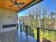 Relaxing outdoor balcony with stone fireplace and ceiling fan overlooks wooded backyard at 914 Laurel Creek Ln, Charlotte, NC 28211