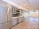 Finished basement kitchenette with grey cabinets, stainless fridge and stylish lighting at 914 Laurel Creek Ln, Charlotte, NC 28211