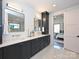Modern bathroom featuring double sinks, sleek cabinetry, and a glimpse of an adjacent bedroom at 914 Laurel Creek Ln, Charlotte, NC 28211