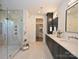 Elegant bathroom showcasing a glass-enclosed shower, double vanity, and walk-in closet at 914 Laurel Creek Ln, Charlotte, NC 28211